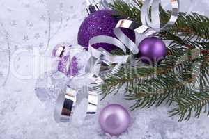 beautiful christmas decoration in purple and silver on white snow