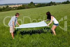 young couple outdoor in summer on blanket in love