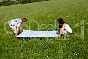 young couple outdoor in summer on blanket in love