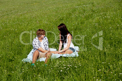 young couple outdoor in summer on blanket in love