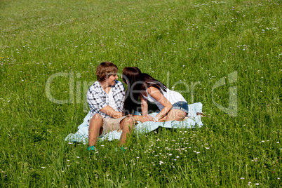 young couple outdoor in summer on blanket in love