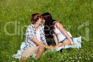 young couple outdoor in summer on blanket in love