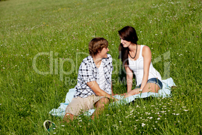 young couple outdoor in summer on blanket in love