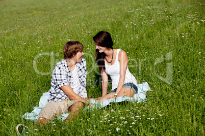 young couple outdoor in summer on blanket in love