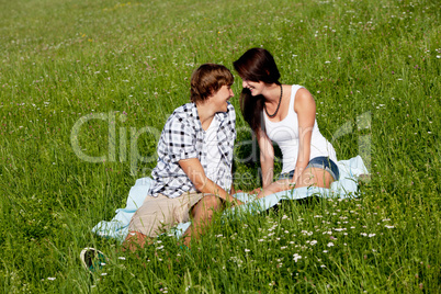 young couple outdoor in summer on blanket in love