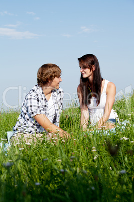 young couple outdoor in summer on blanket in love