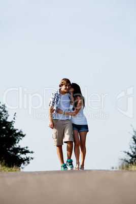 young woman and man is walking on a road in summer outdoor