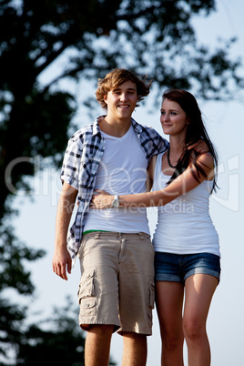young woman and man is walking on a road in summer outdoor