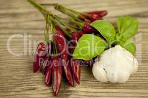 red hot chilli pepper with basil and garlic on table