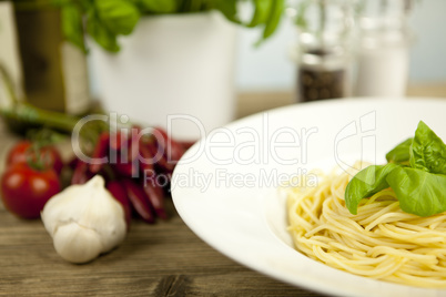 tasty fresh pasta with garlic and basil on table