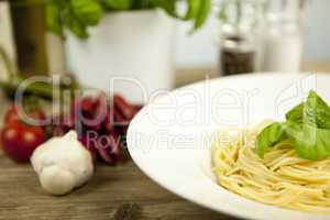 tasty fresh pasta with garlic and basil on table