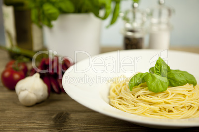 tasty fresh pasta with garlic and basil on table