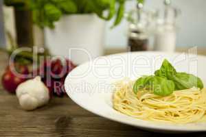 tasty fresh pasta with garlic and basil on table