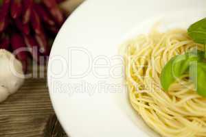 tasty fresh pasta with garlic and basil on table