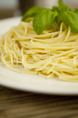 tasty fresh pasta with garlic and basil on table