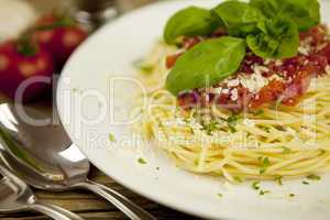fresh pasta with tomato sauce and basil on wooden table