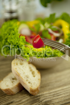 fresh tasty healthy mixed salad and bread on table