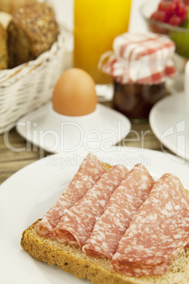 tasty breakfast with salami toast on table