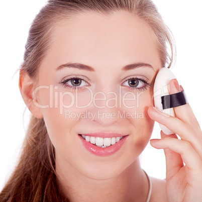 young beautiful woman applying mineral powder