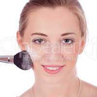 beautiful woman applying make up on face