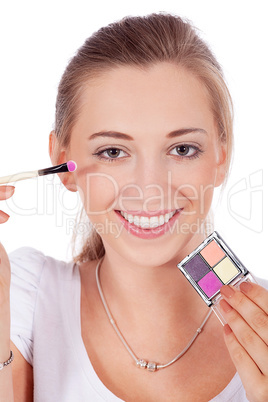 young beautiful woman applying eyeshadow on eyes