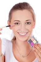young beautiful woman applying eyeshadow on eyes