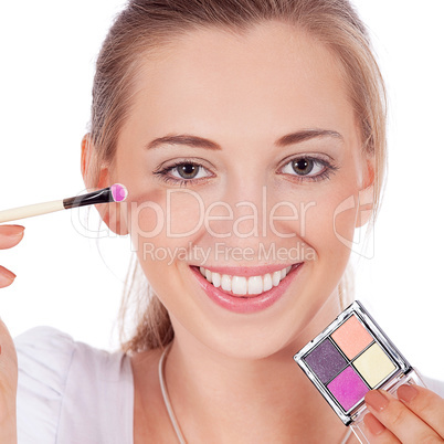 beautiful woman applying make up on face