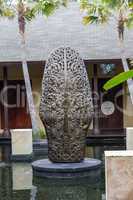 Ornate column in formal Balinese garden