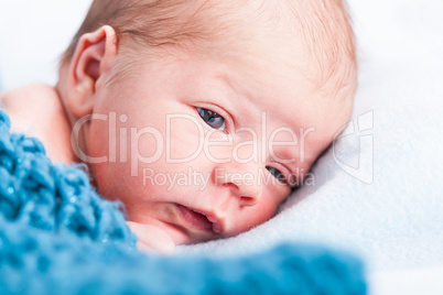 Small infant wrapped in knitted fabric