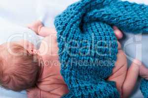 Small infant wrapped in knitted fabric