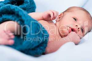 Small infant wrapped in knitted fabric