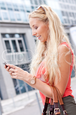 attractive young blonde woman talking on the phone outdoor