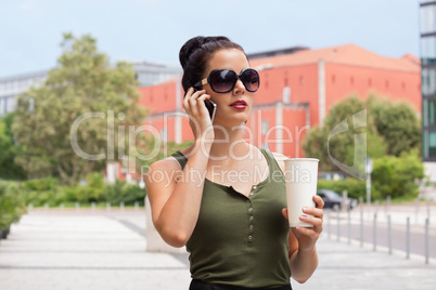 attractive young woman with smartphone and sunglasses outdoor