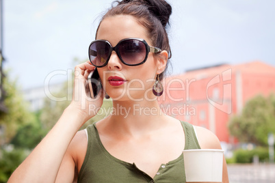 attractive young woman with smartphone and sunglasses outdoor