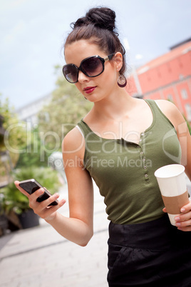 attractive young woman with smartphone and sunglasses outdoor