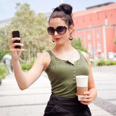 attractive young woman with smartphone and sunglasses outdoor