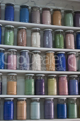 Shelving with glass jars of colorful pigments