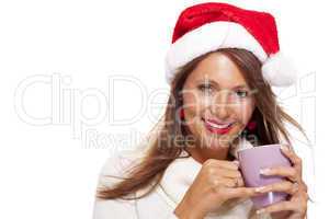 Cold young woman in a Santa hat sipping coffee tea