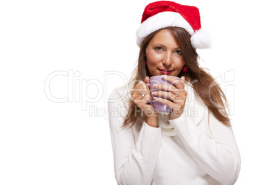 Cold young woman in a Santa hat sipping coffee tea