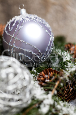 Silver Christmas bauble on a tree with snow