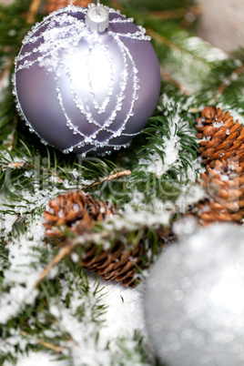 Silver Christmas bauble on a tree with snow