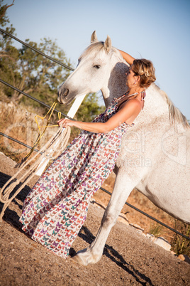 young woman walking a road with horse