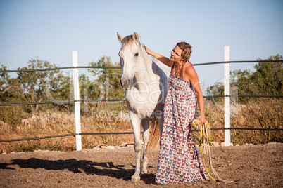 young woman walking a road with horse