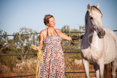 young woman walking a road with horse