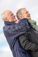 happy elderly senior couple walking on beach