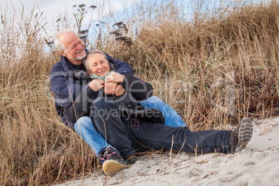 happy mature couple relaxing baltic sea dunes