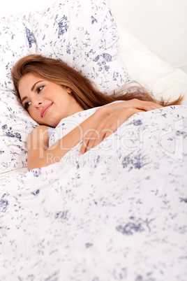 young brunette woman lying in bed sleeping morning