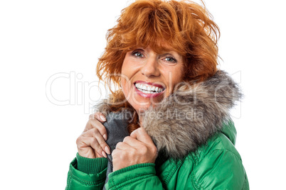 redhead smiling adult mature woman with geen warm jacket