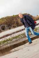 Elderly energetic man running along a beach