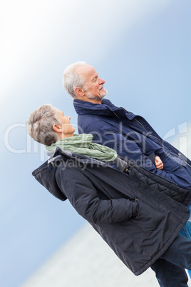 happy elderly senior couple walking on beach